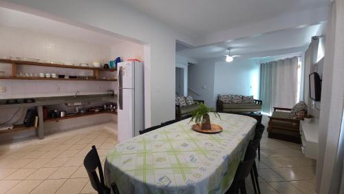 a kitchen with a table and a refrigerator in a room at Pousada Vila ÁguaMar in Itapoa