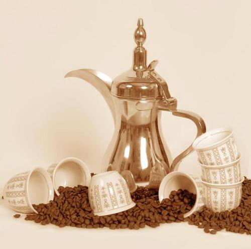 a tea kettle and coffee beans on a table at Kareem celebrations Hall صاله افراح in Irbid