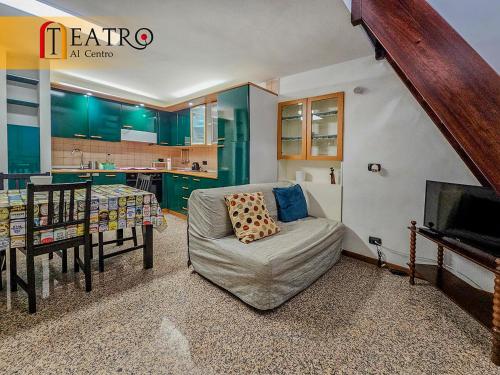 a living room with a chair and a table and a kitchen at Teatro al Centro in Ancona