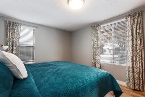 a bedroom with a green bed and a window at #StayInMyDistrict Historic Charming Bungalow in Twin Falls