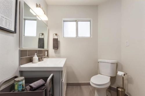 a bathroom with a white toilet and a sink at #StayInMyDistrict Historic Charming Bungalow in Twin Falls