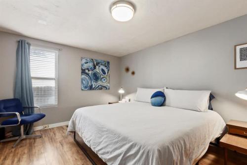 a bedroom with a large bed and a blue chair at #StayInMyDistrict Historic Charming Bungalow in Twin Falls
