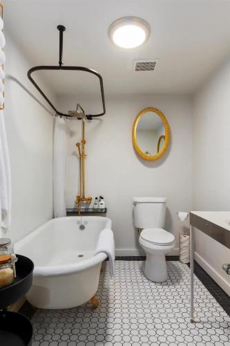 a white bathroom with a tub and a toilet at #StayInMyDistrict Historic Charming Bungalow in Twin Falls