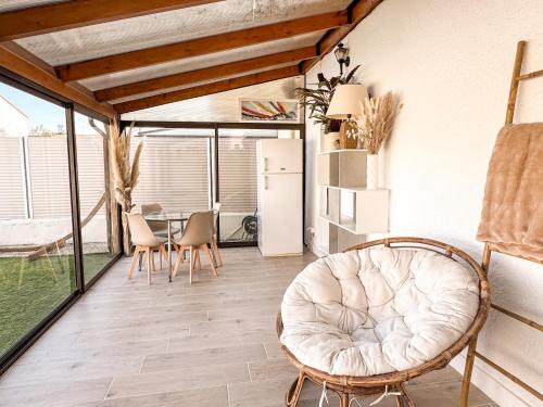 - un salon avec une chaise blanche et une table dans l'établissement La Sardane de Rose et Victoire, à Saint-Estève