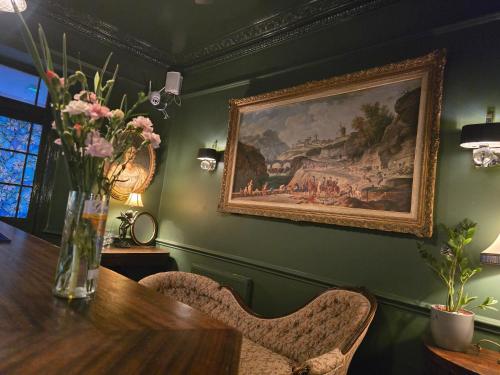 a dining room with a vase of flowers on a table at Queens Court Hotel in Exeter