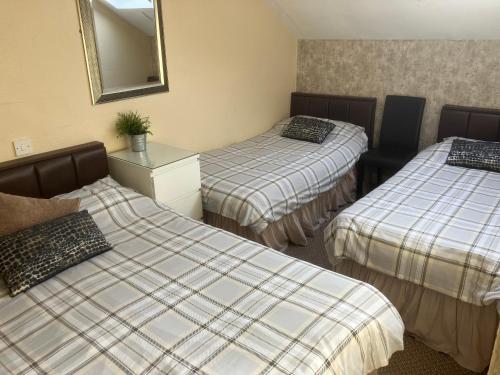 a hotel room with two beds and a mirror at Pearl Hotel in Blackpool