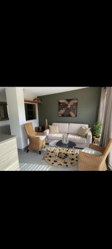 un salon avec un canapé, une table et des chaises dans l'établissement Jolie pavillon avec jardin privé, à Cagnes-sur-Mer