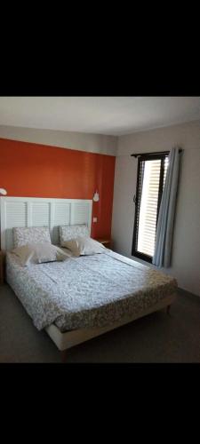 une chambre avec un grand lit et une fenêtre dans l'établissement Jolie pavillon avec jardin privé, à Cagnes-sur-Mer