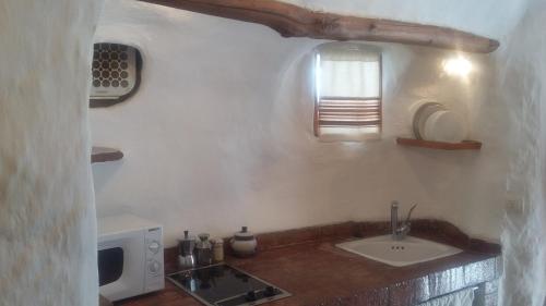 a kitchen with a sink and a microwave at Al Jatib in Baza