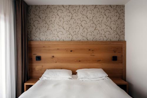 a bed with two white pillows in a bedroom at Hotel Montana in Vason