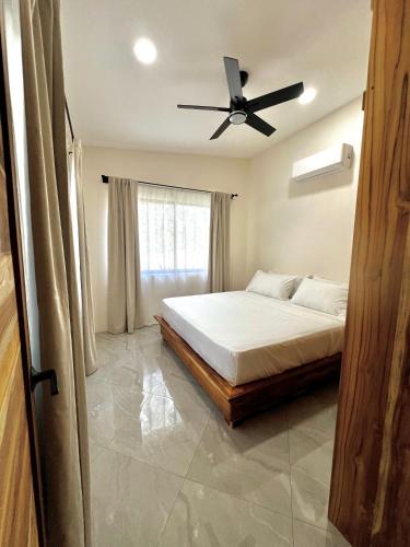 a bedroom with a bed and a ceiling fan at Casa María - Playa hermosa Cóbano in Playa hermosa