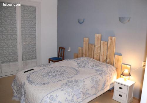 une chambre avec un lit avec une tête de lit en bois dans l'établissement Maison de campagne dans le vignoble Gallacois, à Gaillac