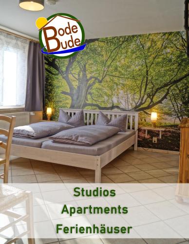 a bedroom with a bed with a tree mural at BodeBude in Thale