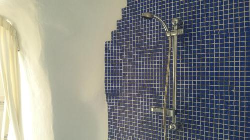 a shower in a bathroom with a blue tile wall at Al Jatib in Baza