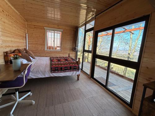 a bedroom with a bed and a large window at Farm stay cabin in the woods in Slade