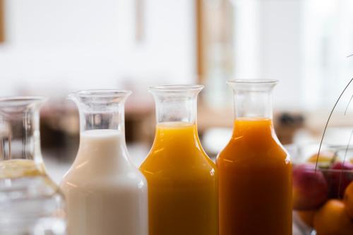 three bottles of milk and orange juice on a table at Das Kaya Hotel Stuttgart Airport Messe in Filderstadt