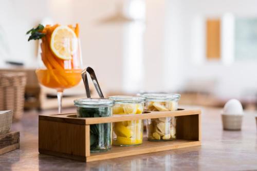 a wooden tray with jars of food on a table at Das Kaya Hotel Stuttgart Airport Messe in Filderstadt
