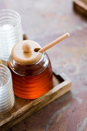 a jar of honey with a wooden spoon in it at Das Kaya Hotel Stuttgart Airport Messe in Filderstadt