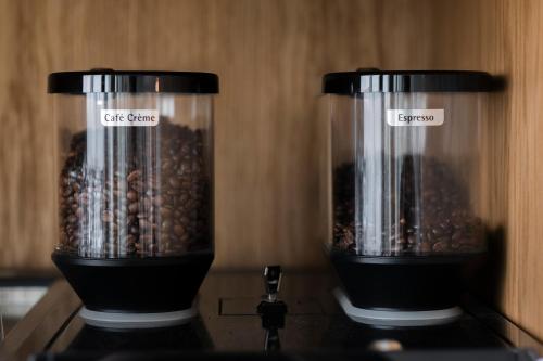 two blenders sitting on top of a stove with coffee beans at Das Kaya Hotel Stuttgart Airport Messe in Filderstadt