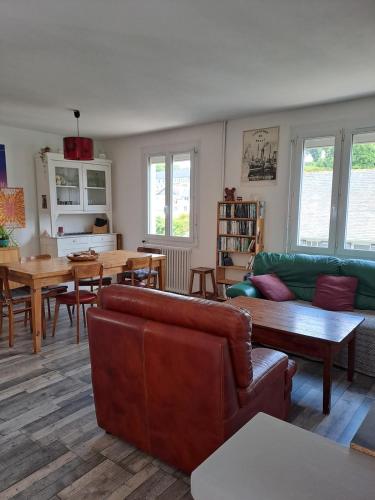un salon avec un canapé, une table et des chaises dans l'établissement Charmante maison dans le centre historique de Morlaix, à Morlaix