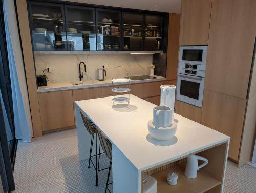 a kitchen with a white island with cups on it at Savoy Residence City Loft - Style and Sophistication in Funchal
