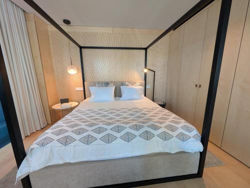 a bedroom with a bed with a black and white comforter at Savoy Residence City Loft - Style and Sophistication in Funchal