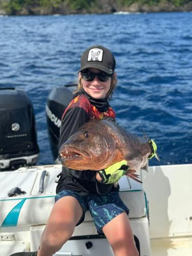 a girl holding a large fish on a boat at Casa Tanamera in Boca Chica