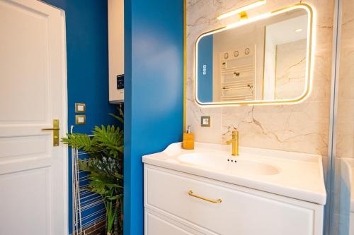 a bathroom with a white sink and a mirror at Le Montrouge BEL APPARTEMENT CONFORT GLAM CHIC in Montrouge