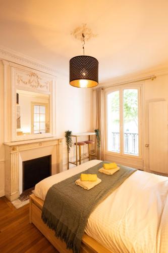 une chambre avec un lit avec deux serviettes dessus dans l'établissement Le Montrouge BEL APPARTEMENT CONFORT GLAM CHIC, à Montrouge