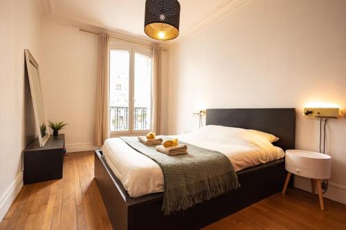 a bedroom with a large bed with towels on it at Le Montrouge BEL APPARTEMENT CONFORT GLAM CHIC in Montrouge