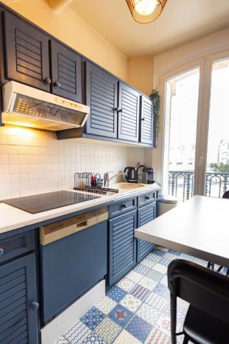 une cuisine avec des armoires bleues et un comptoir dans l'établissement Le Montrouge BEL APPARTEMENT CONFORT GLAM CHIC, à Montrouge