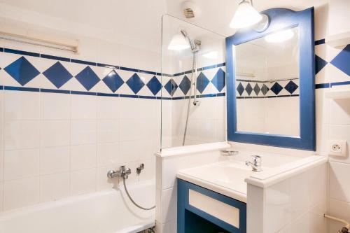 une salle de bain avec un lavabo, une baignoire et un miroir dans l'établissement Les Maisons de Port Bourgenay - maeva Home - Maison 3 pièces 8 personnes - Sélection MAE-6213, à Talmont-Saint-Hilaire