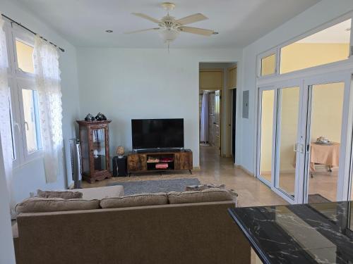 a living room with a couch and a flat screen tv at Casa Tanamera in Boca Chica