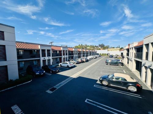 a parking lot with cars parked in front of buildings at The Hills Inn Eagle Rock - Near Old Town Pasadena in Los Angeles