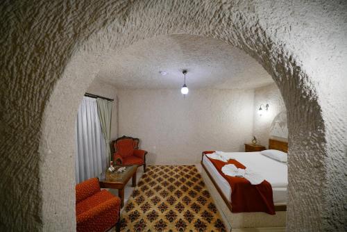 a hotel room with a bed and a chair at Glory Art Stone House in Goreme