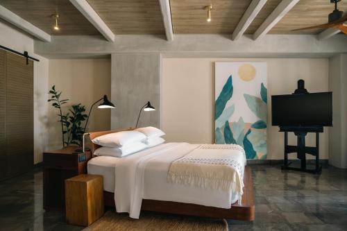 a bedroom with a bed and a flat screen tv at Atelier Playa Mujeres- Adults Only - All Inclusive Resort in Cancún