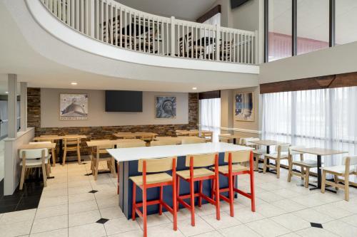 グランドラピッズにあるAmericInn by Wyndham Grand Rapids Airport Northのテーブルと椅子とテレビのあるダイニングルーム