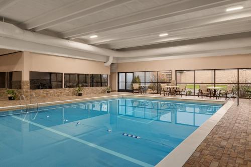 a pool with blue water in a building at AmericInn by Wyndham Grand Rapids Airport North in Grand Rapids