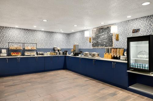 a restaurant with a counter with blue cabinets and a counter at AmericInn by Wyndham Grand Rapids Airport North in Grand Rapids