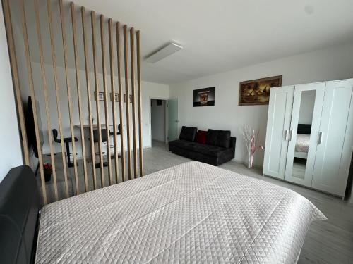 a bedroom with a bed and a couch at KOMFORT FerienWohnung NeuBau Merzig in Merzig