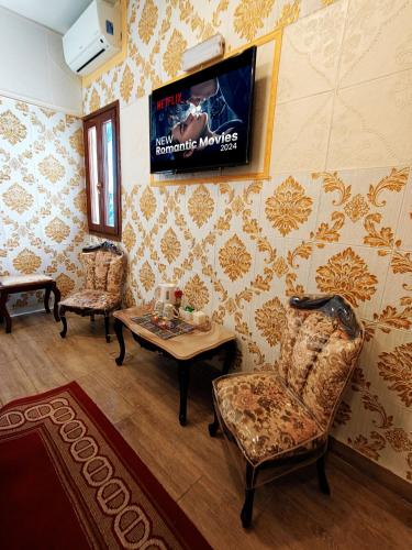 a living room with a tv and a table and chairs at Jessica Flat Malta Royal Guesthouse in Cospicua
