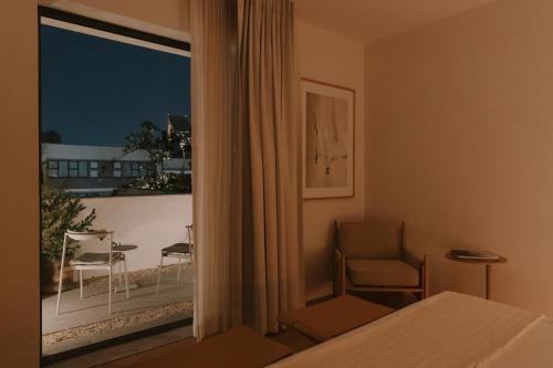a room with a bed and a window with a chair at Casa Ofelia in Mexico City