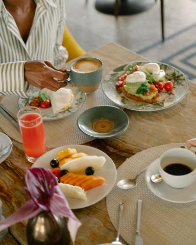 a table with plates of food and a cup of coffee at Copacabana Palace, A Belmond Hotel, Rio de Janeiro in Rio de Janeiro