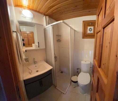 a small bathroom with a toilet and a sink at Turkuaz Bungalows in Cıralı