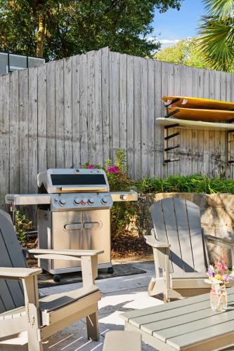 a backyard with a stove and two chairs and a fence at Folliday Inn - The Overnighter - Room 25 in Folly Beach