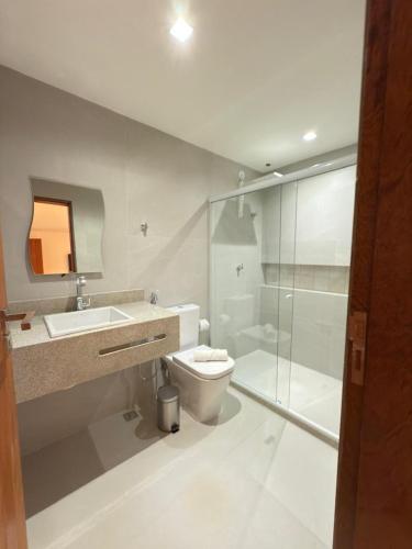 a bathroom with a toilet and a sink and a shower at Pousada Mariá in Cabo Frio