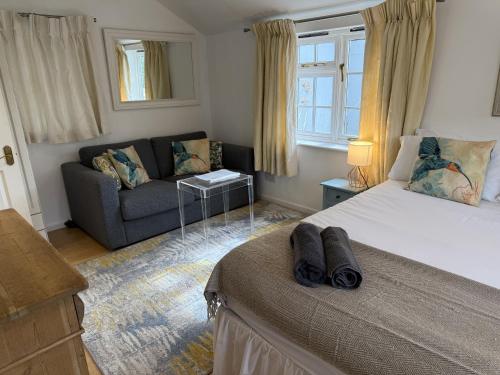 a bedroom with a large bed and a couch at The Guesthouse Hideaway by Newfo.rest in Hordle