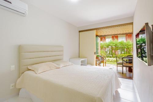 a white bedroom with a bed and a balcony at IT99 Lindo Apto 3/4 Pé na Areia - Itacimirim in Camacari