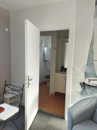- un salon avec une porte menant à une salle de bains dans l'établissement Kerbugalic GR34, à Trévou-Tréguignec