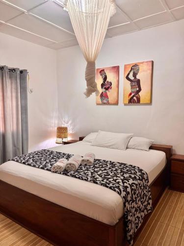 a bedroom with a bed with a black and white comforter at Paloma Guest House in Kenema